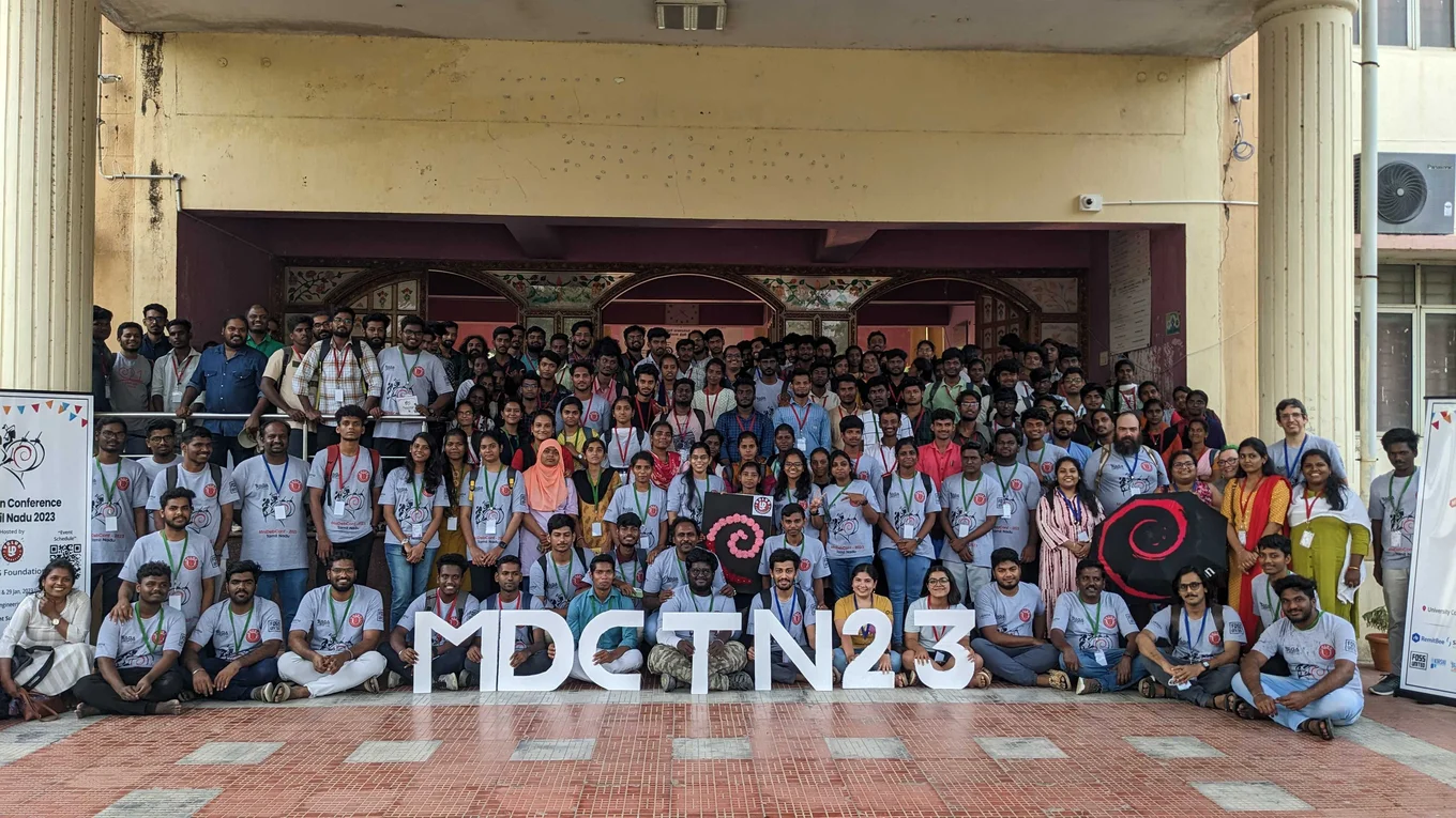 Large group posing; letters "MDCTN23"; banners.